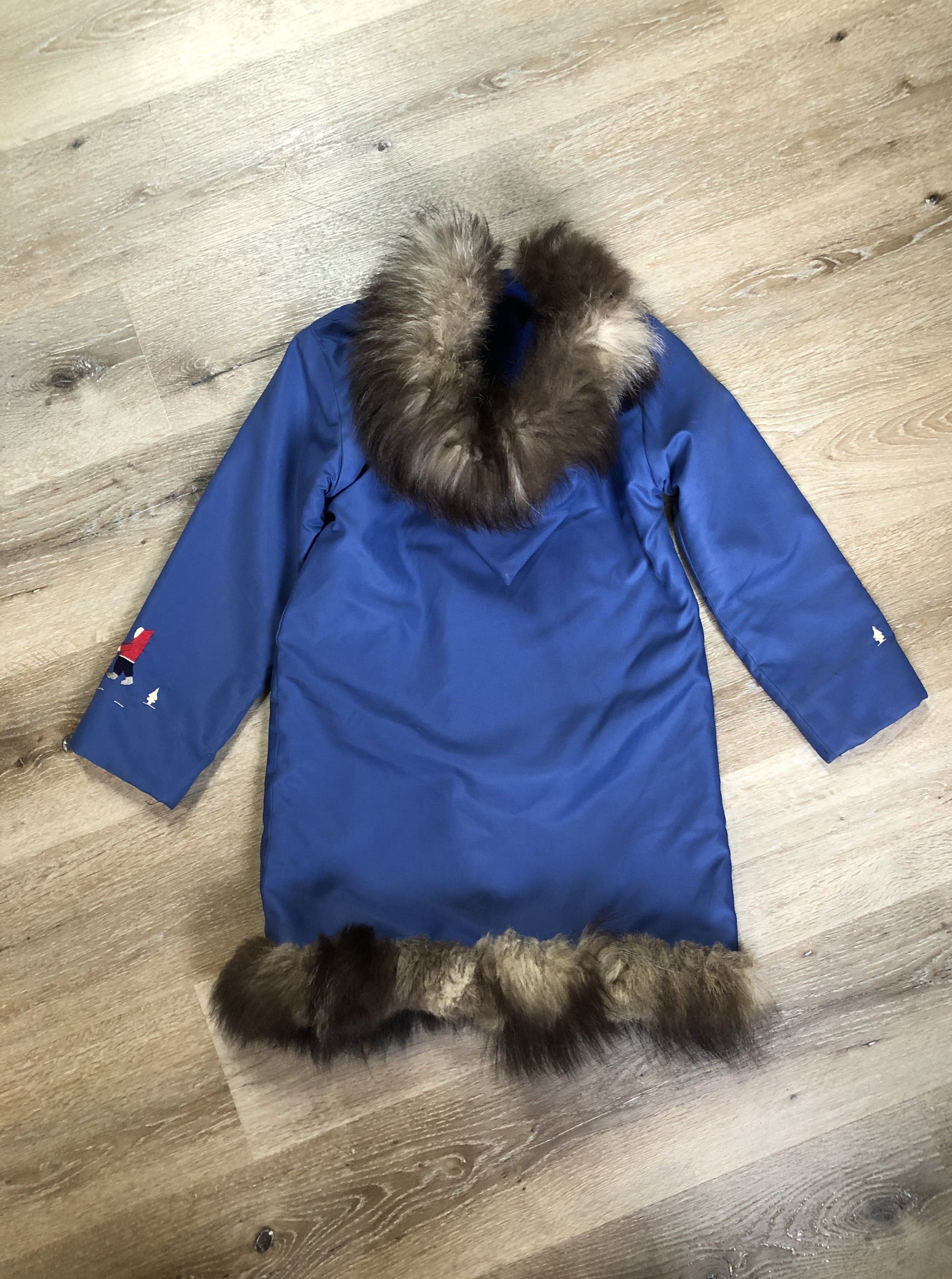 Kingspier Vintage - Children’s blue northern parka featuring a hood, fur trim and pom poms, zipper closure, wool lining, patch pockets, embroidered winter scenes along the front. Made in Canada. 