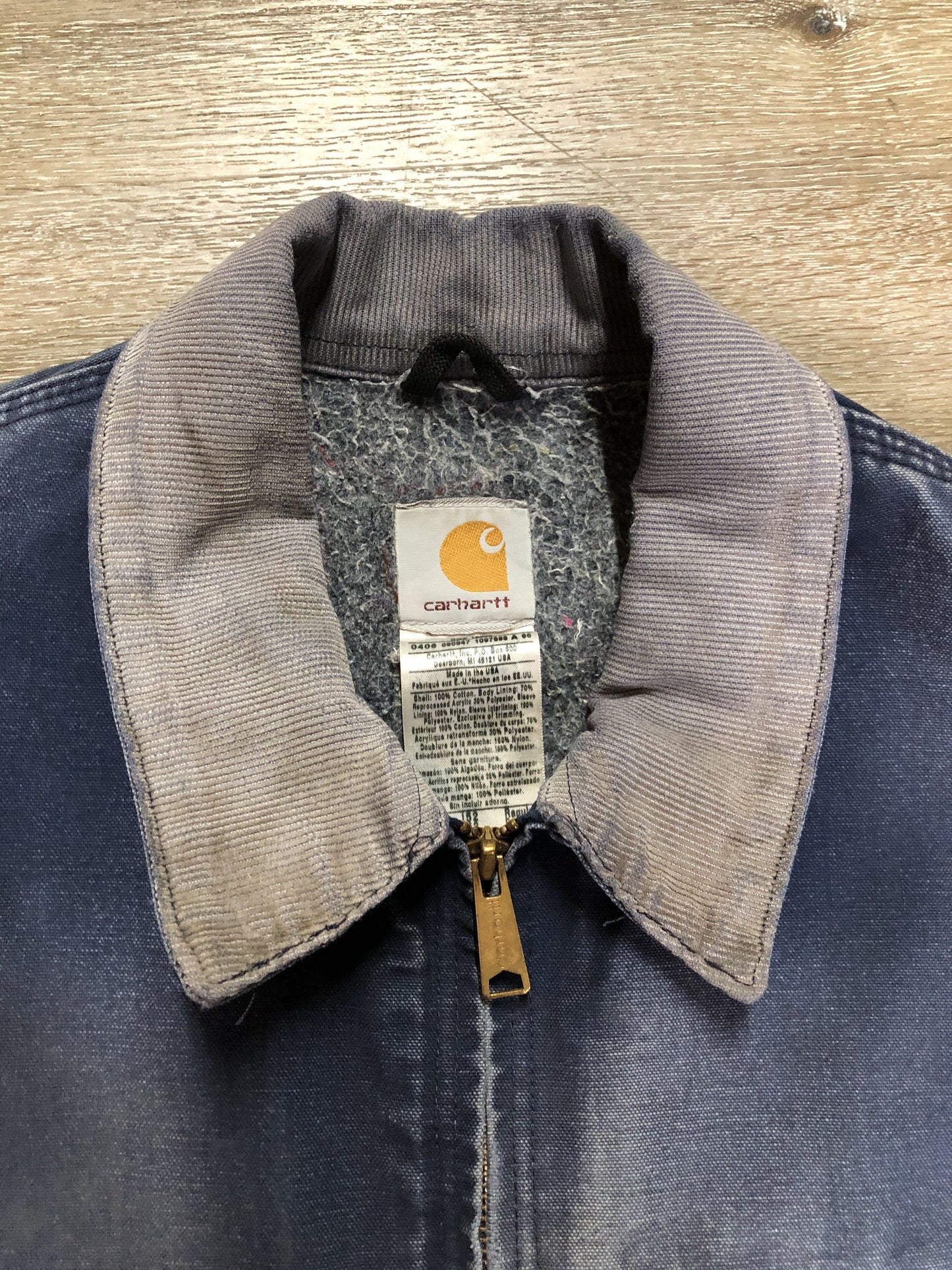 Kingspier Vintage - Carhartt blue canvas chore jacket with beige corduroy collar. The jacket is distressed with frayed edges, wool lining, one zip pocket on the chest and two slash pockets. Made in the USA.