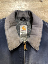 Load image into Gallery viewer, Kingspier Vintage - Carhartt blue canvas chore jacket with beige corduroy collar. The jacket is distressed with frayed edges, wool lining, one zip pocket on the chest and two slash pockets. Made in the USA.
