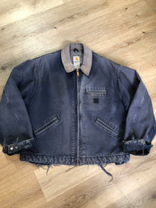 Kingspier Vintage - Carhartt blue canvas chore jacket with beige corduroy collar. The jacket is distressed with frayed edges, wool lining, one zip pocket on the chest and two slash pockets. Made in the USA.
