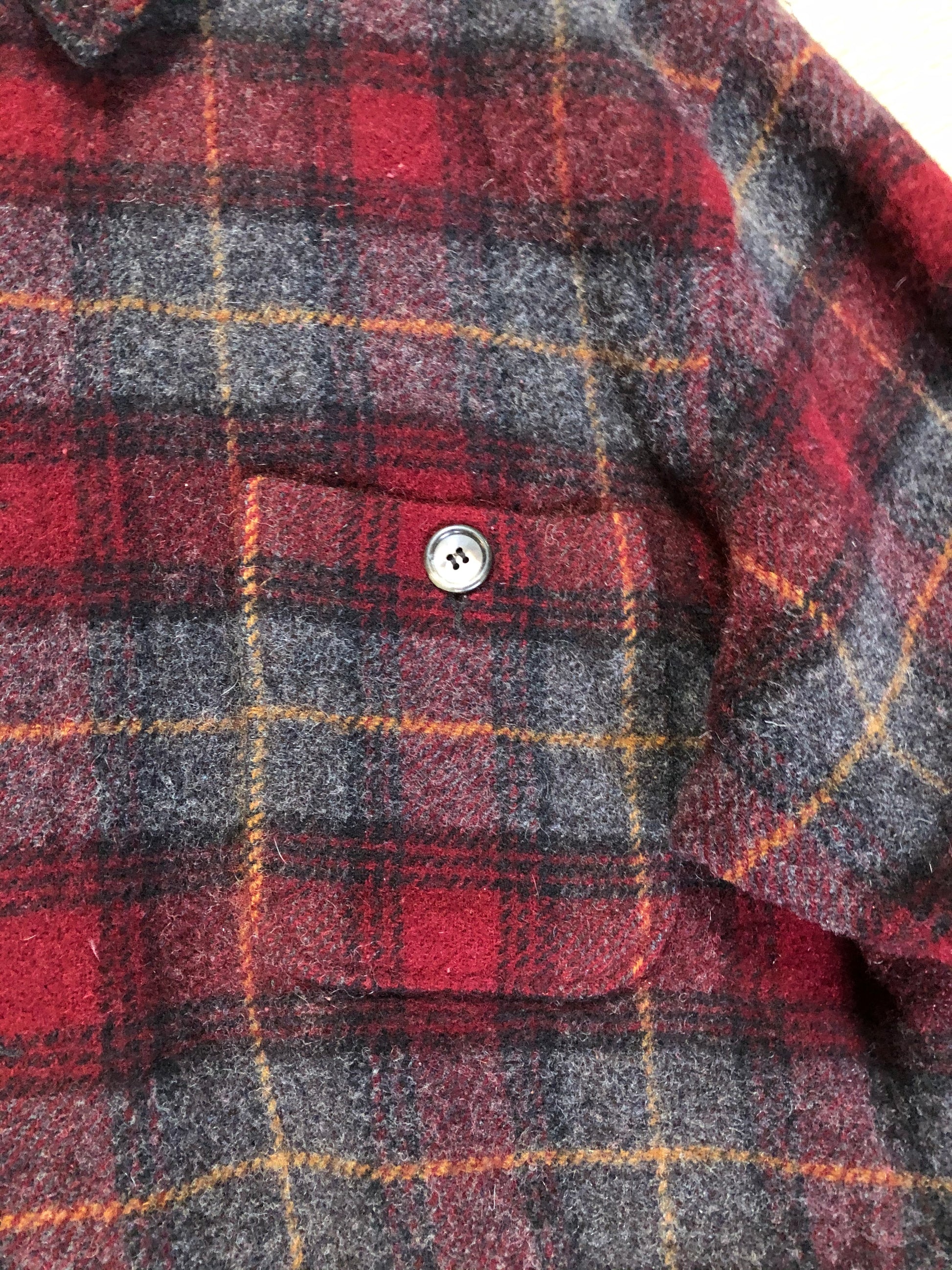 Kingspier Vintage - Woolrich red and grey plaid wool lumberjack shirt with button closures and one patch pocket on the chest.