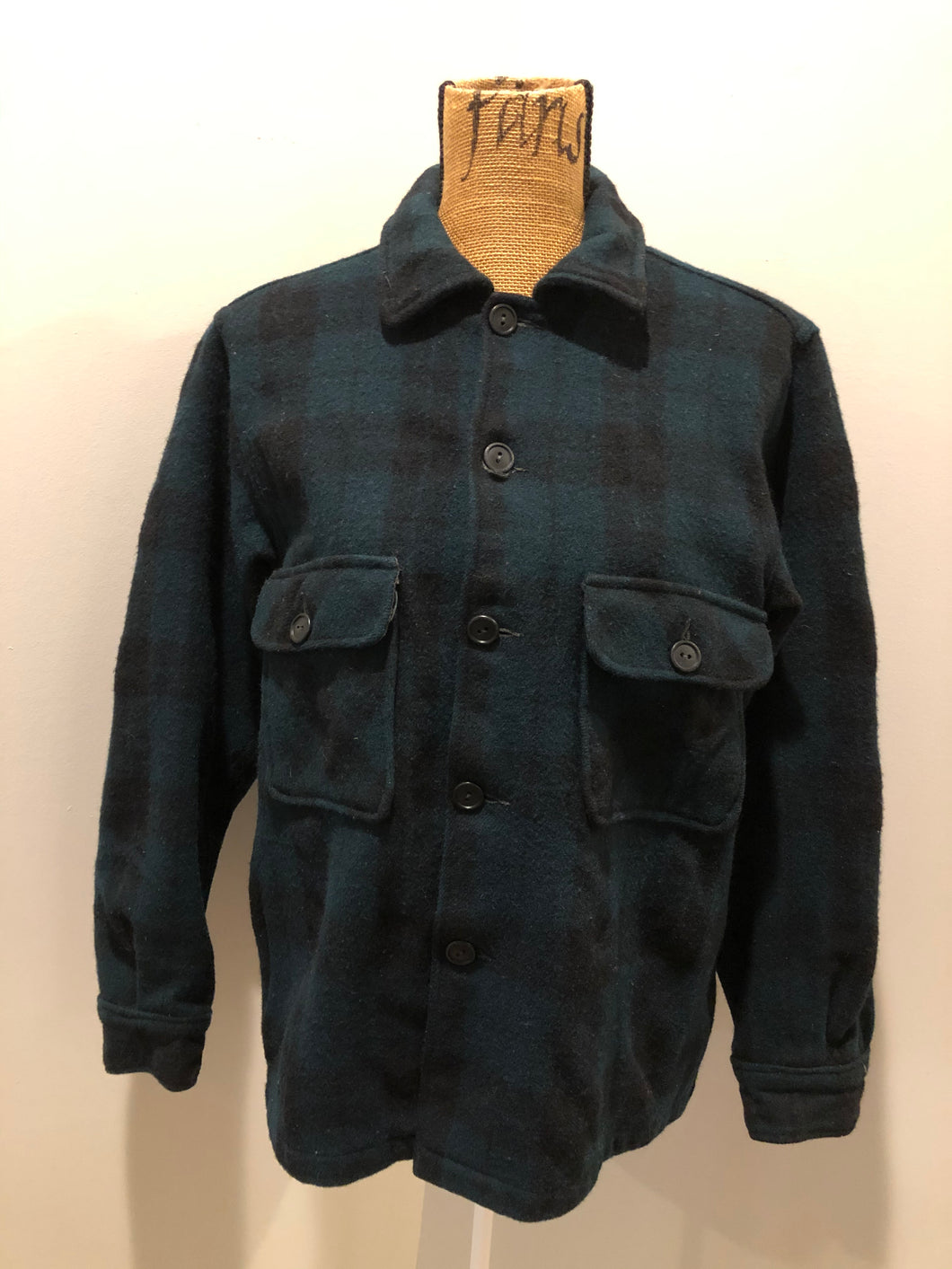 Kingspier Vintage - Woolrich dark green plaid wool lumberjack shirt with button closures and two flap pockets on the chest.