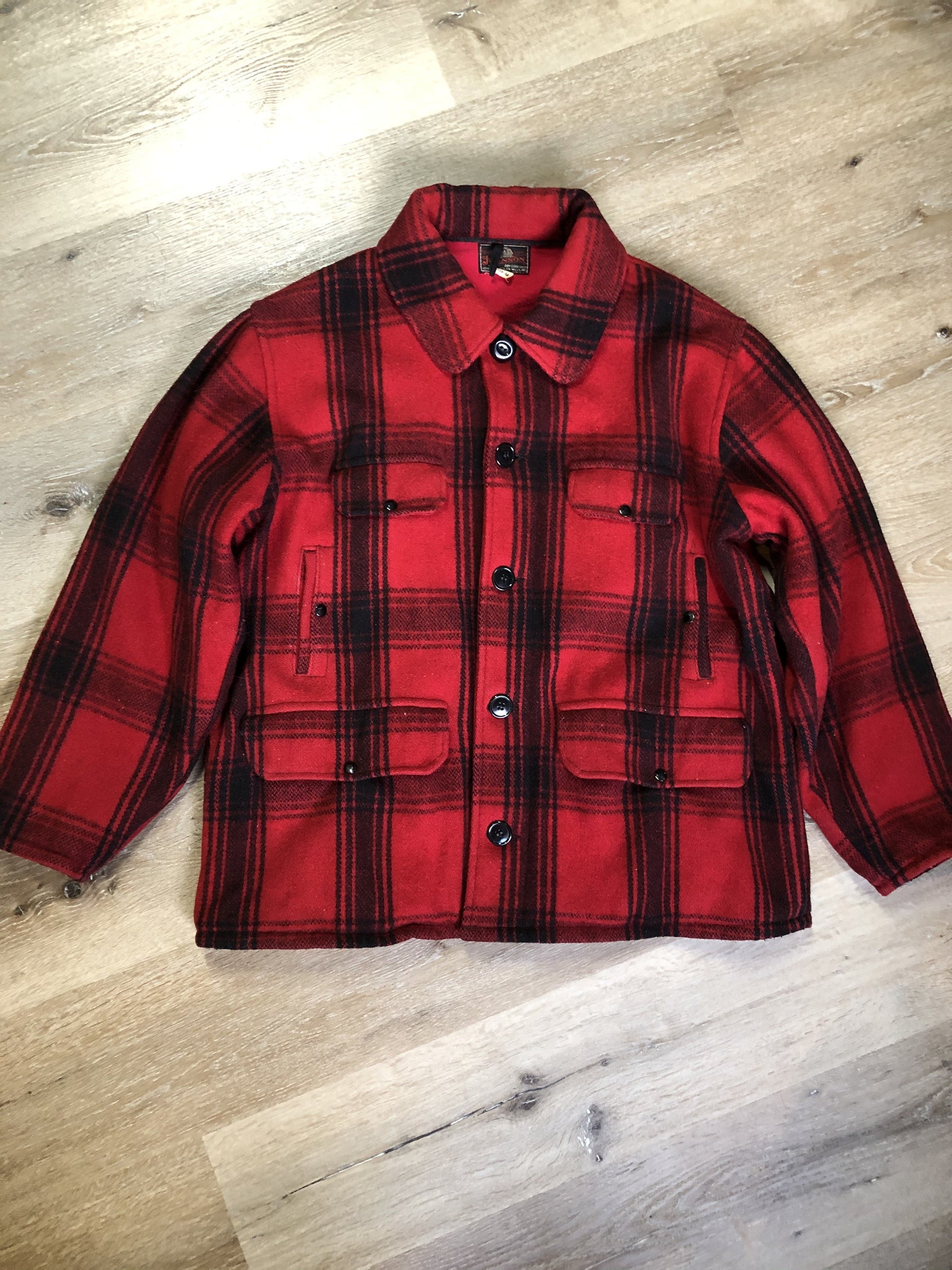 Kingspier Vintage - Johnson Woolen Mills red plaid wool hunting jacket with button closures, inside knit cuffs to keep cold air out, four flap pockets, two hand warming pockets, two side zip pockets and one inside pocket.