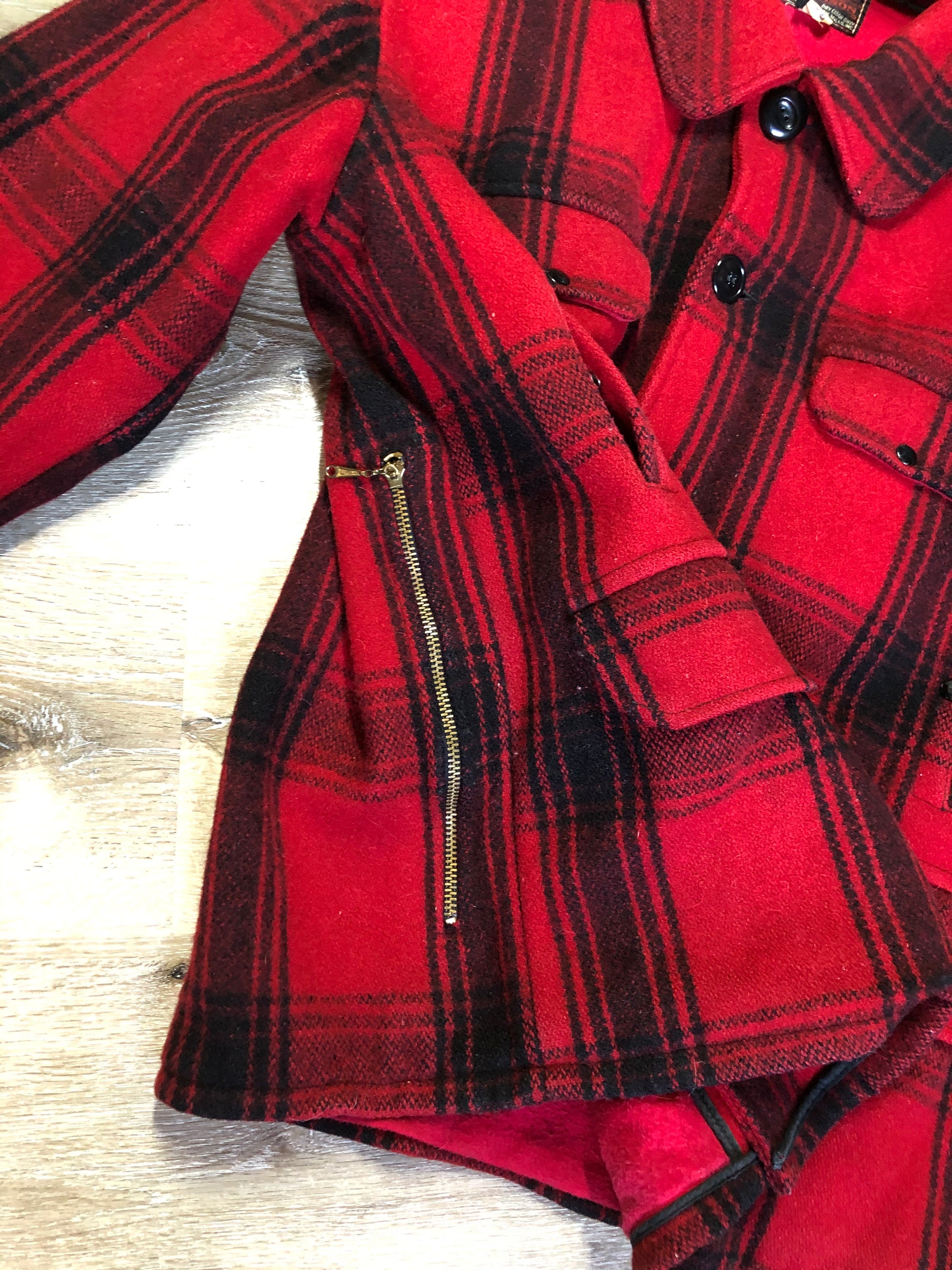 Kingspier Vintage - Johnson Woolen Mills red plaid wool hunting jacket with button closures, inside knit cuffs to keep cold air out, four flap pockets, two hand warming pockets, two side zip pockets and one inside pocket.