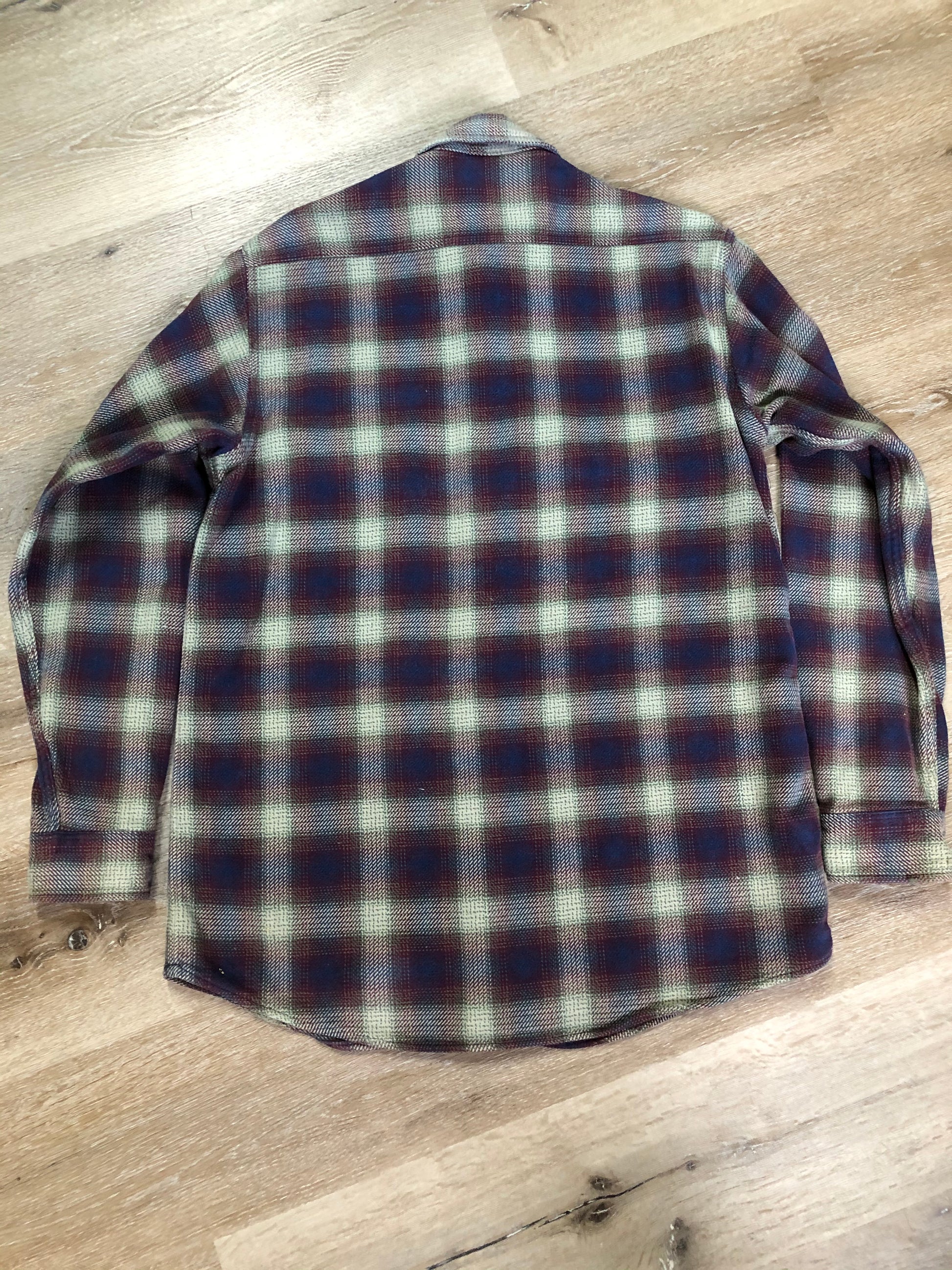 Kingspier Vintage - Herman Survivor faded blue red and green plaid lumberjack shirt with button closures and two flap pockets on the chest. Size large.