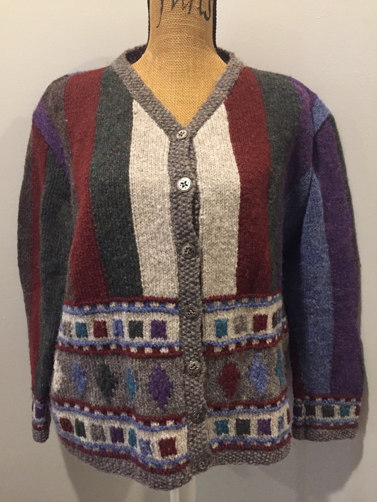 Kingspier Vintage - Hand knit cardigan with grey/green/red/purple/blue design and button closures. Size medium.