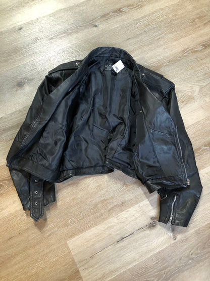 Kingspier Vintage - Cosa Nova black leather motorcycle jacket with two slash pockets, one flap pocket and a belt at the waist. Made in Canada. Size large.