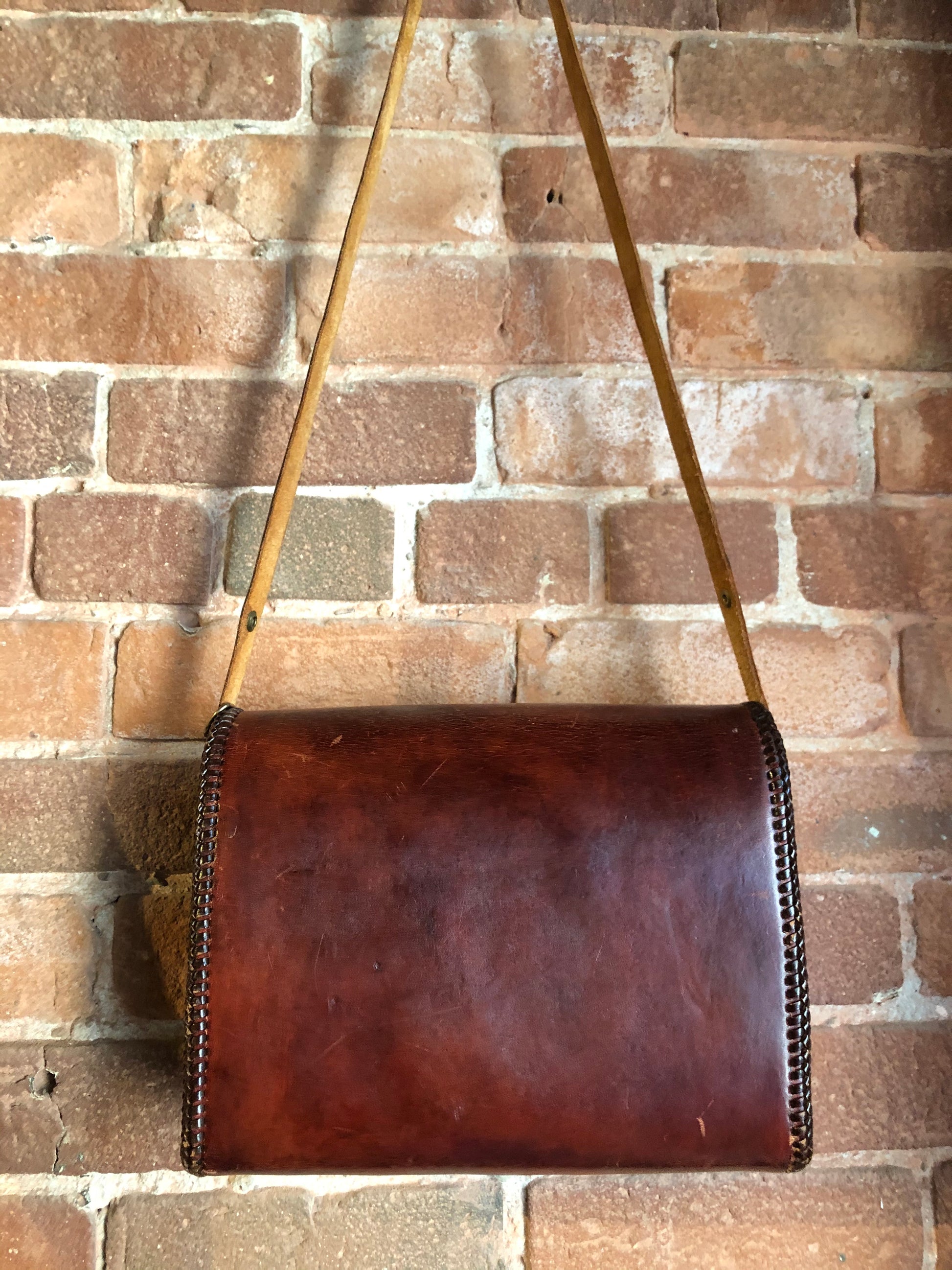 Kingspier Vintage - Hand tooled brown leather purse with leather stitching around the trim and a red leather flower motif lining.