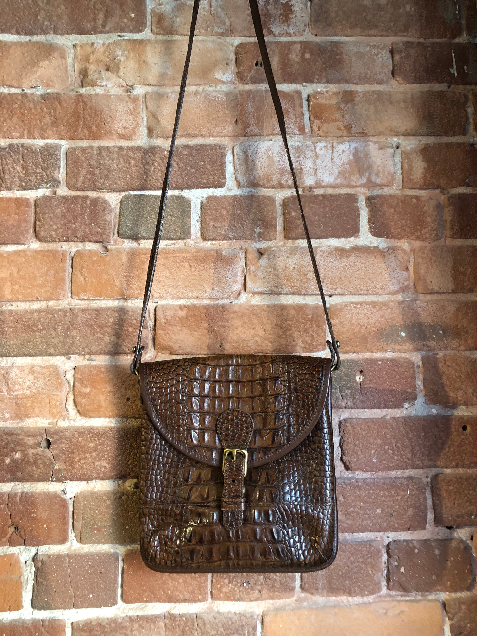 Kingspier Vintage - Brahmin croc-embossed leather crossbody handbag in pecan brown. This bag features brass hardware, snap buckle closure, back pocket and inside zip pocket. Made in the USA.