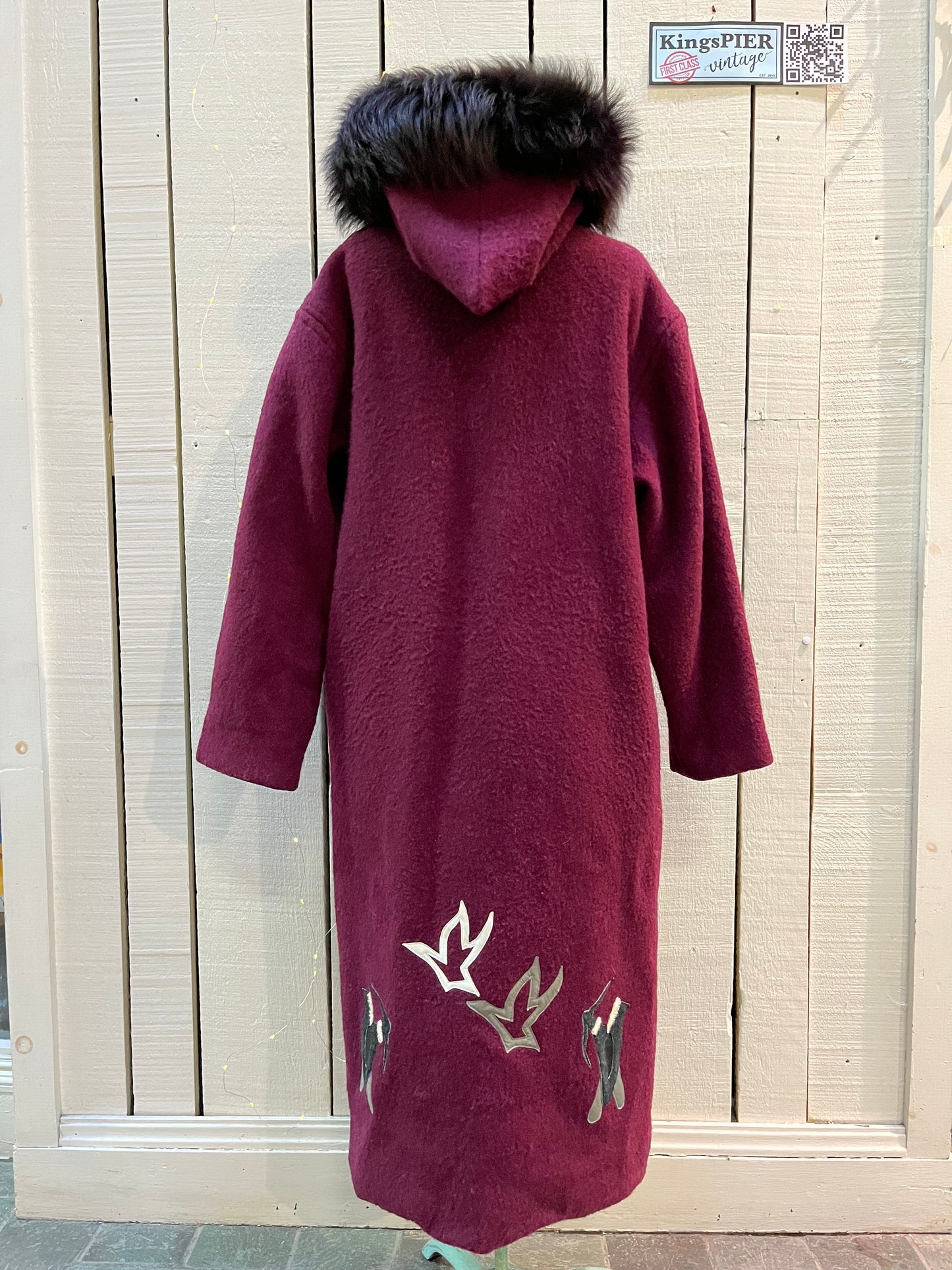 Vintage 100% wool long northern parka with zipper closure, front pockets, fur trimmed hood and suede applique in a bow and arrow hunting motif.
 
Indigenous made
Chest 46”