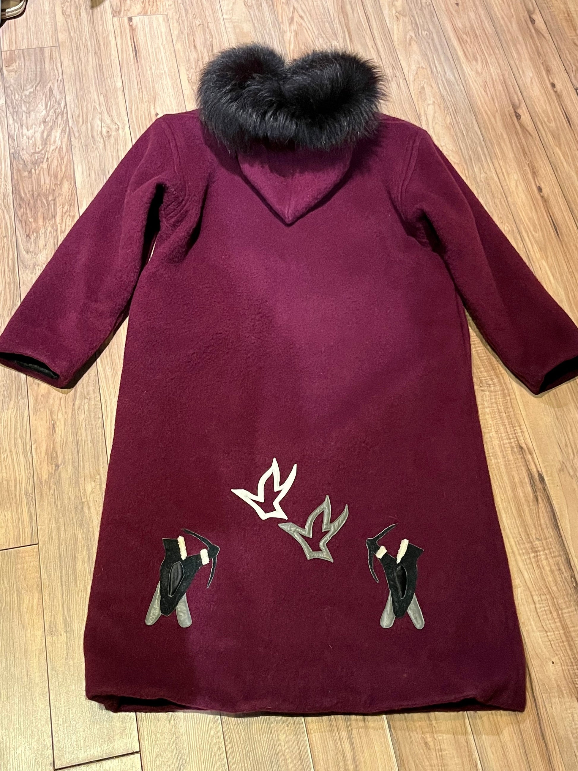 Vintage 100% wool long northern parka with zipper closure, front pockets, fur trimmed hood and suede applique in a bow and arrow hunting motif.
 
Indigenous made
Chest 46”