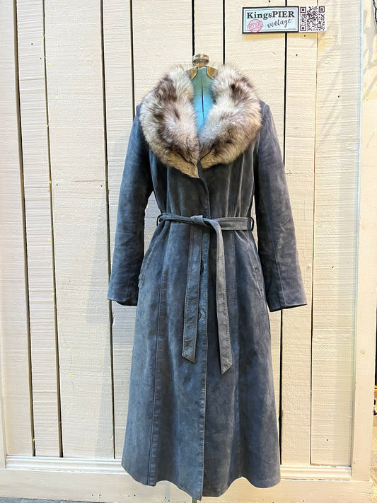 Vintage Leather Attic long blue/grey suede coat with white fur collar, belt, two front pockets, button closures and a quilted lining.
Made in Canada, Size 13/14