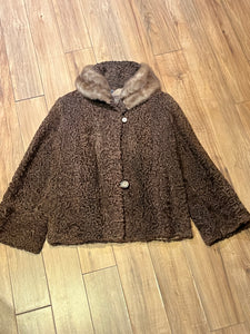 Vintage Brunswick Furriers brown persian lamb jacket with fur collar, two front pockets, flower decorated button closures and a “N.G.S” monogram on the inside lining.

Made in Canada, Chest 38”