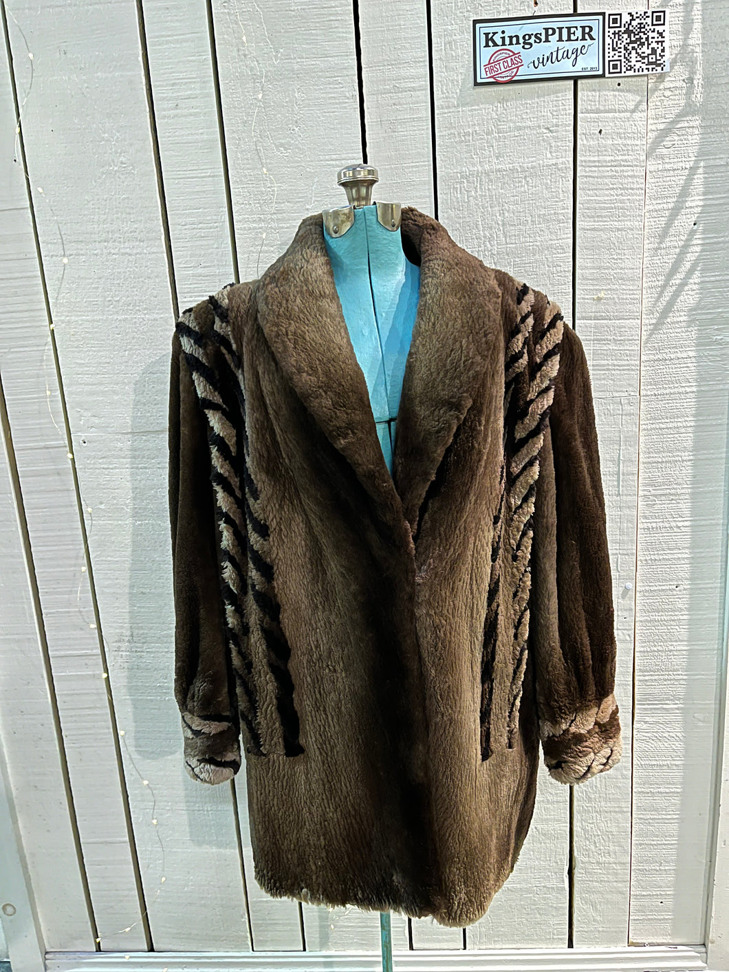Vintage Eastern Furriers brown fur coat with hook and eye closures and two front pockets.

Although we can’t say for sure what the type of fur is, our educated guess is shorn beaver.

Made in Canada