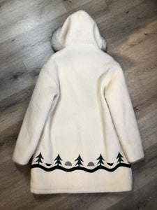 Kingspier Vintage - Hudson’s Bay Company white pure virgin wool northern parka featuring a hood with fox fur trim, zipper closure, quilted lining, inside drawstring, slash pockets, hidden knit cuffs and tree a nd igloo design suede appliqué on the front and back. Made in Canada. Size 14/ large. 
