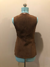 Load image into Gallery viewer, Vintage Mills Brothers deadstock 1960’s brown suede vest with large gold geometric front clasp, leather lining and trim and two patch pockets in the front. Suede and leather are buttery soft. Made in England - Kingspier Vintage
