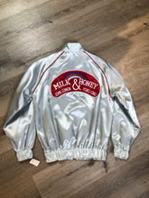 Load image into Gallery viewer, Kingspier Vintage - Milk and Honey - John Lennon and Yoko Ono Roadie Tour Jacket from the mid 1980’s. A very rare collectors piece from John Lennon’s last studio album. Jacket is light grey nylon with satin effect with two slash pockets, elastic waist and cuffs, chunky red zip up front with popper at the collar. The jacket features a star logo on the front and Milk and honey logo on the back with a rainbow. Made in the USA. Size XS. 
