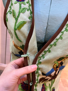 Double D Ranch light green goat suede vest with brown fringe detail, hook and eye closure, cotton/ linen back panel, satin lining and a western cowboy and desert rose design that is hand beaded.

Made in India
Size Medium