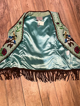 Load image into Gallery viewer, Double D Ranch light green goat suede vest with brown fringe detail, hook and eye closure, cotton/ linen back panel, satin lining and a western cowboy and desert rose design that is hand beaded.

Made in India
Size Medium

