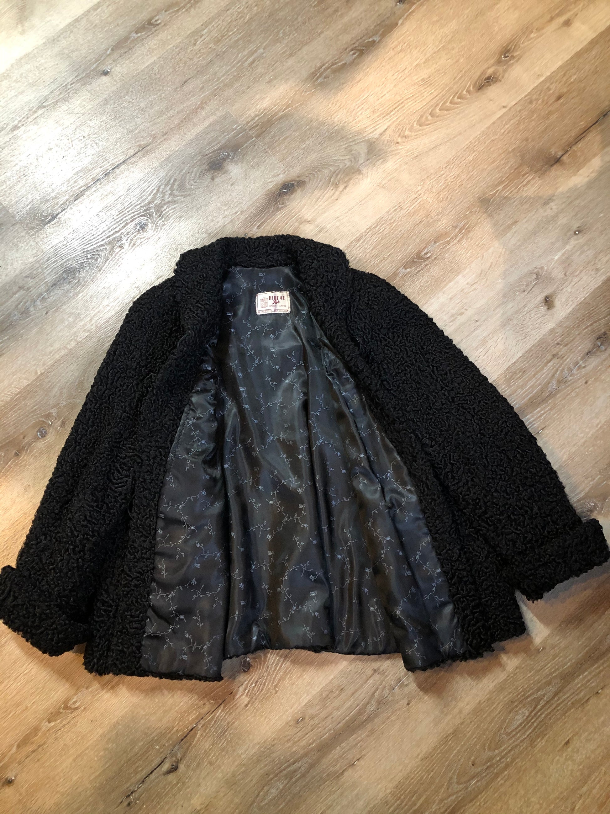 Kingspier Vintage - Vintage Rideau Furs black persian wool coat with wool buttons, pockets and black satin lining with delicate flower motif. Made in Nova Scotia. Size small/ medium.