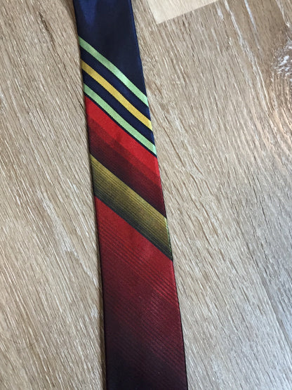 Kingspier Vintage - Playboy tie with navy, red, yellow and green design. Fibres unknown. 

Length: 57.5” 
Width: 2.5” 

This tie is in excellent condition.