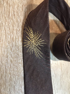 Kingspier Vintage - Frank Struser Original Necktie in brown with gold starburst design. Fibres unknown.

Length: 56.6” 
Width: 2.5” 

This tie is in excellent condition.