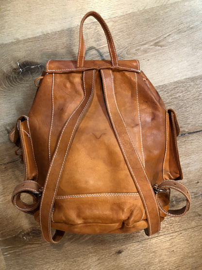 Vintage full grain leather backpack in light brown with top carry handle, flap closure, interior drawstring, three exterior compartments and adjustable shoulder straps Kingspier Vintage