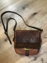 Load image into Gallery viewer, Vintage full grain brown leather crossbody bag with leather fringe, hand tooled designs, brass hardware, flap closure, two interior compartments and adjustable shoulder strap.  Bag is scented with patchouli - Kingspier Vintage
