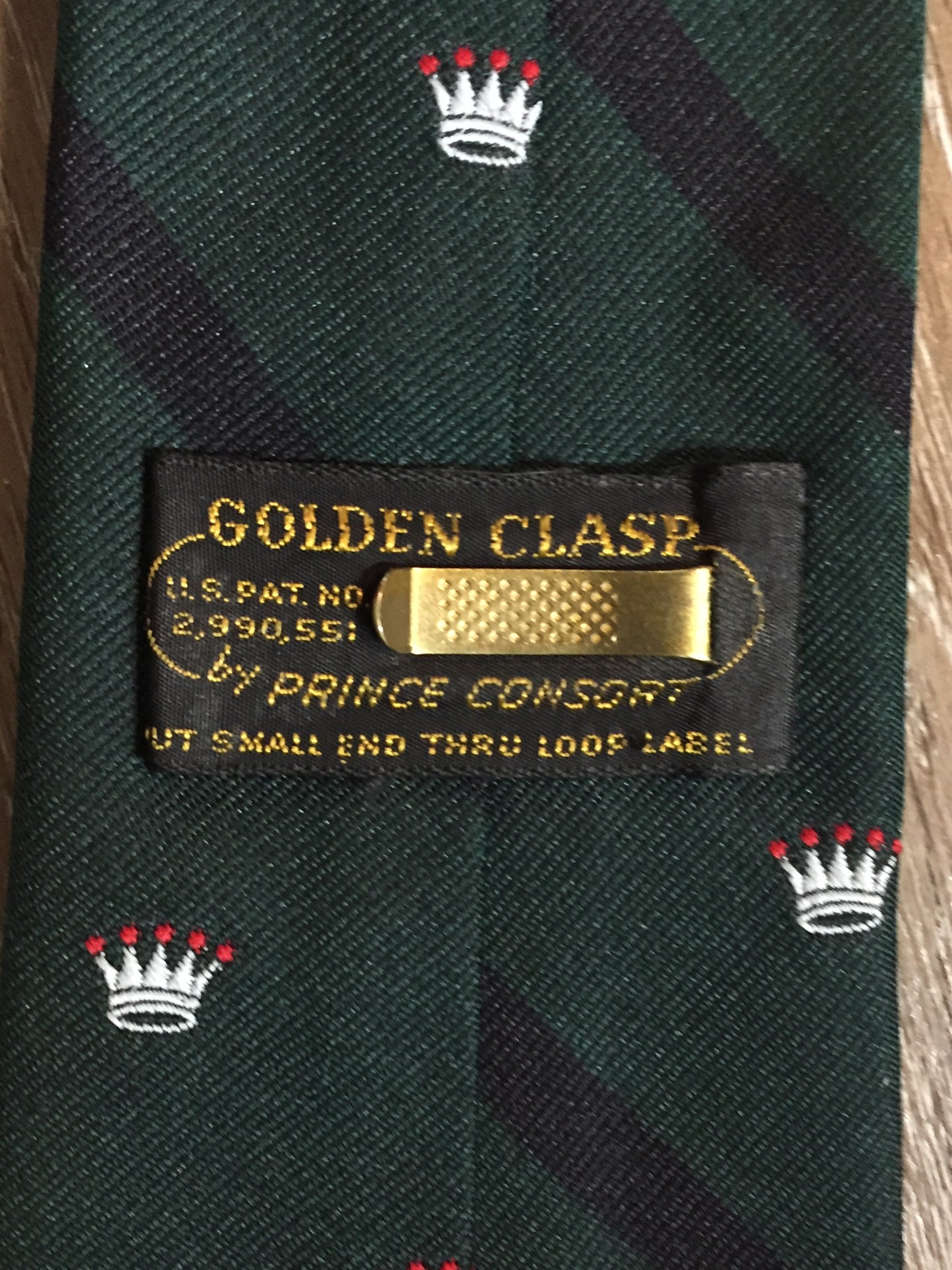 Kingspier Vintage - Golden Clasp by Prince Consort green and navy tie with crown print. Fibres unknown.

Length: 56”
Width: 3”

This tie is in excellent condition.