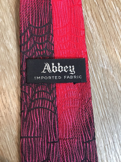 Kingspier Vintage - Abbey red tie with black spider web motif. Fibres unknown.

Length: 55”
Width: 2.5” 

This tie is in excellent condition.