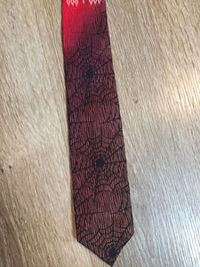 Kingspier Vintage - Abbey red tie with black spider web motif. Fibres unknown.

Length: 55”
Width: 2.5” 

This tie is in excellent condition.