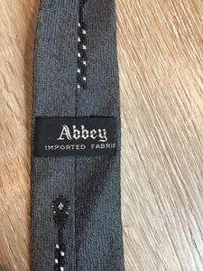 Kingspier Vintage - Abbey tie with grey, black and white pattern. Fibres unknown.

Length: 56” 
Width: 2.25” 

This tie is in excellent condition with some yellowing/ sun damage.