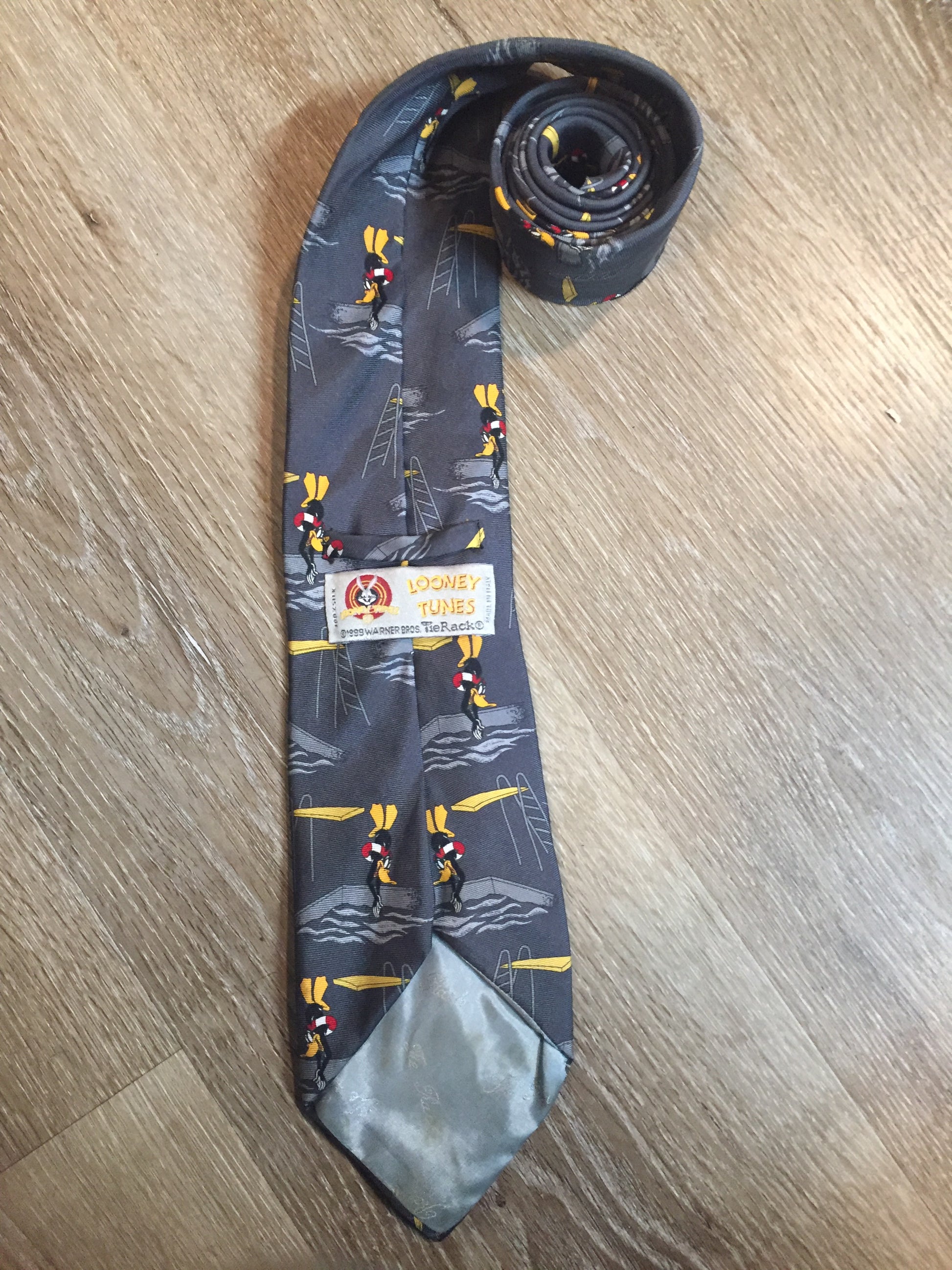 Kingspier Vintage - Looney Toones grey 100% silk tie with Daffy Duck Print. Made in Italy.

Length: 61.5” 
Width: 3.75” 

This tie is in excellent condition.