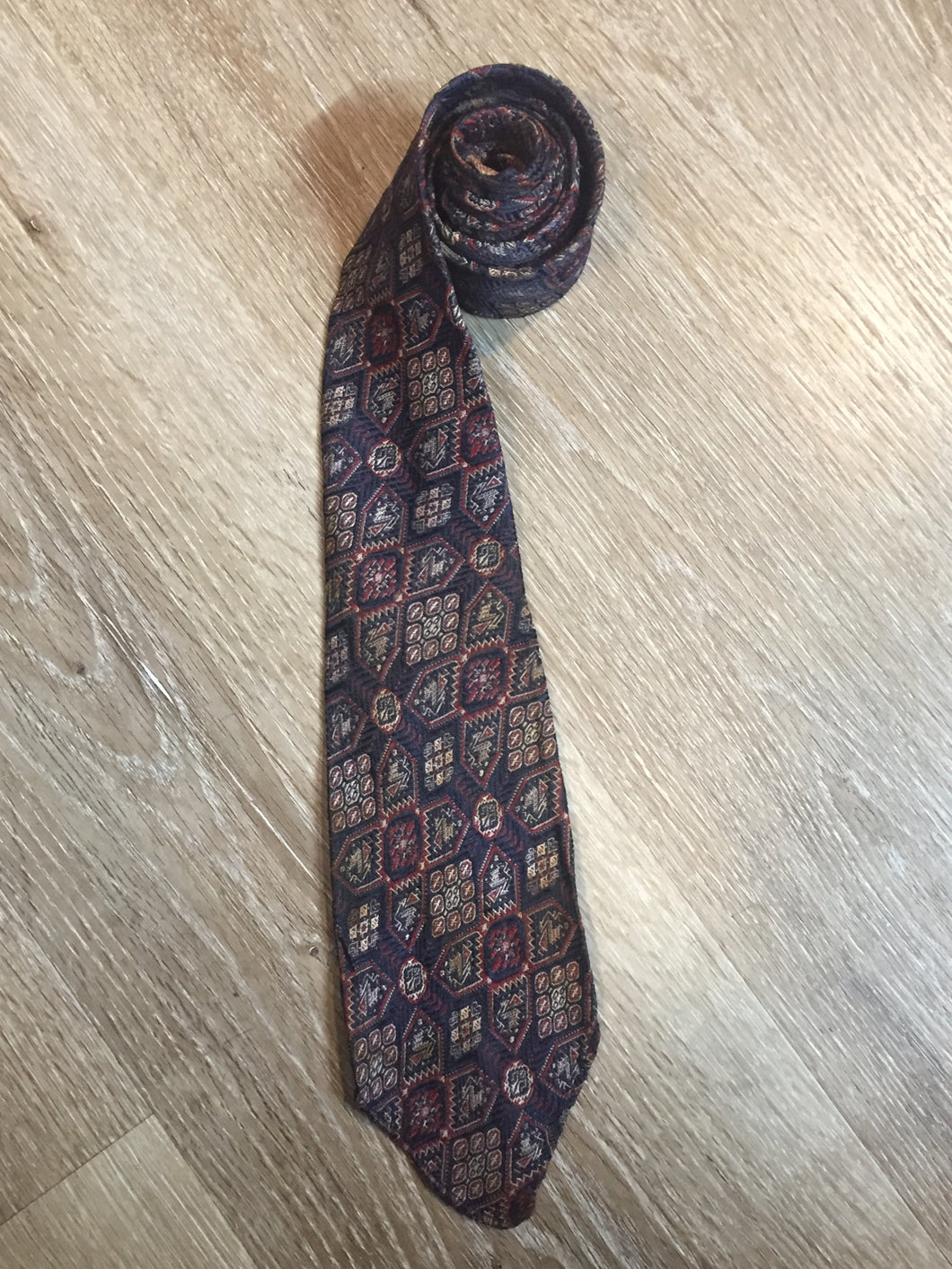 Kingspier Vintage - Currie “Authentic Ancient Persians” with navy, red and cream design. Fibres unknown but feels like sIlk.

Length: 51.5” 
Width: 3” 

This tie is in great condition with some minor wear.