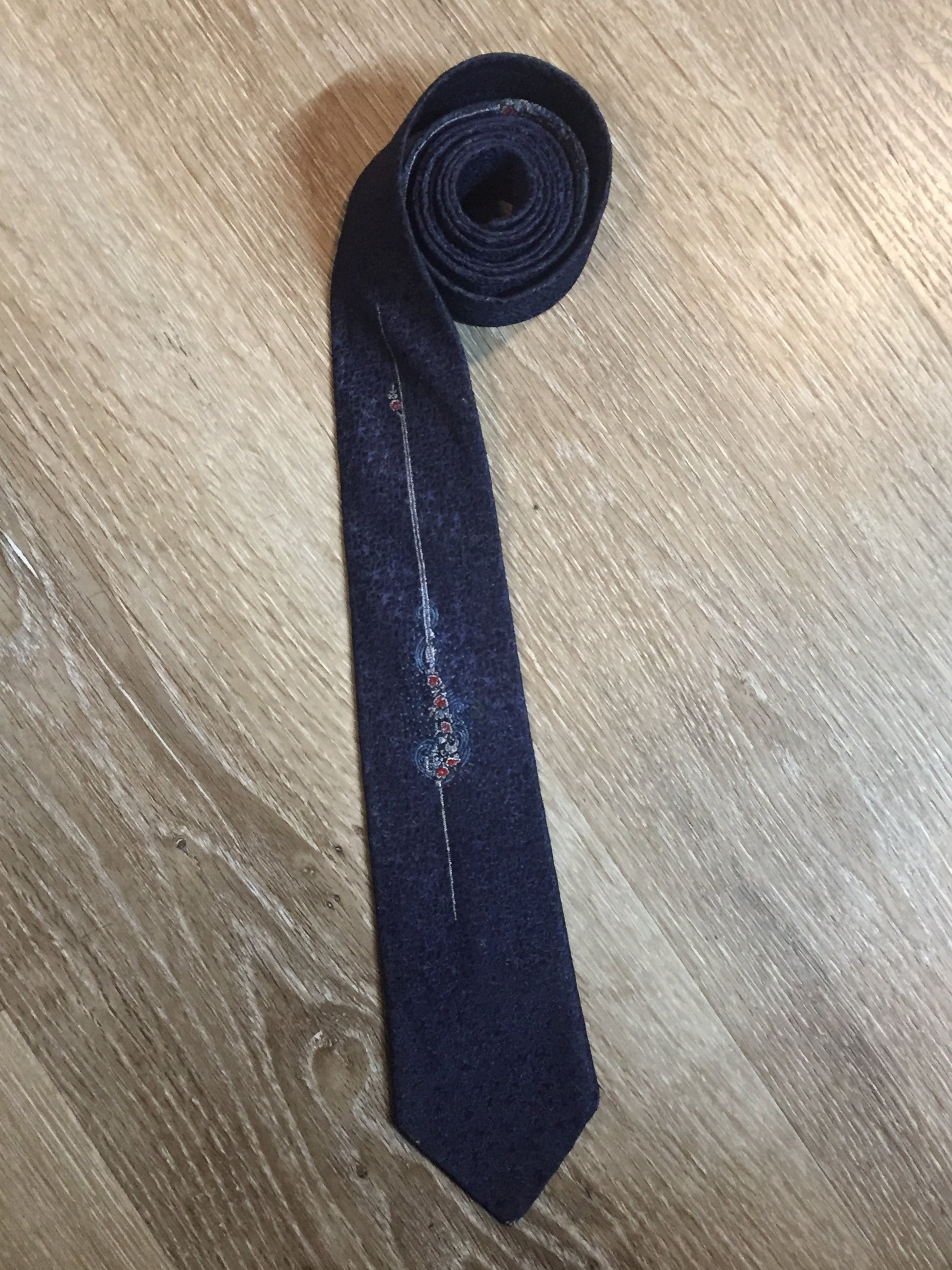 Kingspier Vintage - Vintage dark blue tie with white, light blue and red flower motif. Fibres unknown.

Length: 54.25”
Width: 2.5” 

This tie is in excellent condition.