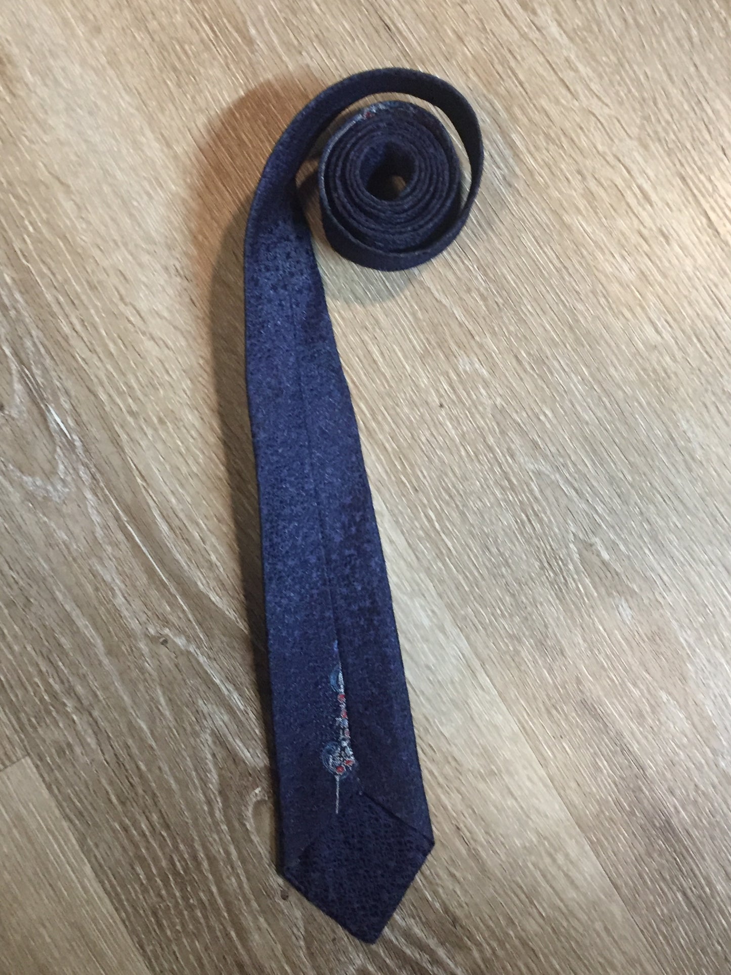 Kingspier Vintage - Vintage dark blue tie with white, light blue and red flower motif. Fibres unknown.

Length: 54.25”
Width: 2.5” 

This tie is in excellent condition.