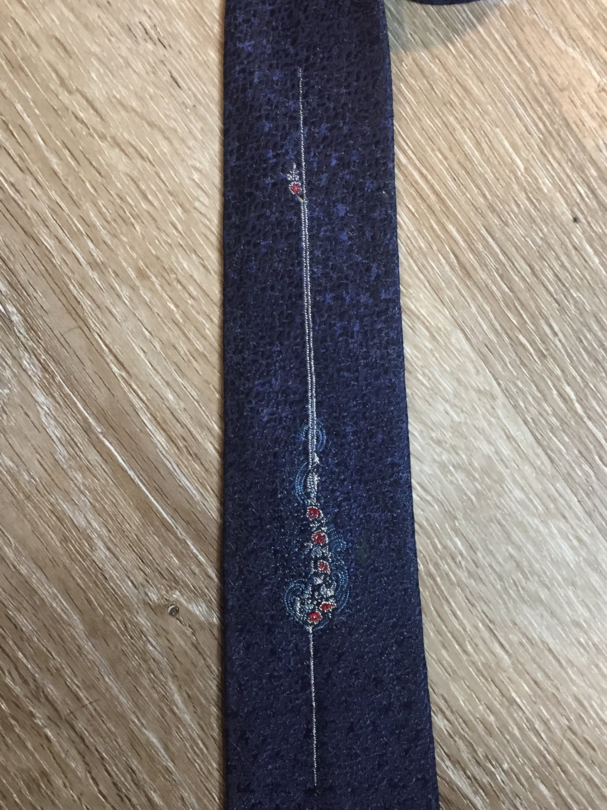 Kingspier Vintage - Vintage dark blue tie with white, light blue and red flower motif. Fibres unknown.

Length: 54.25”
Width: 2.5” 

This tie is in excellent condition.