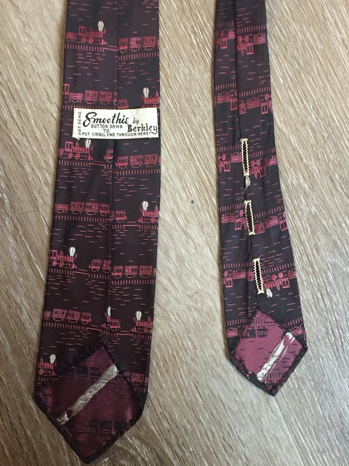 Kingspier Vintage - Berkley “Smoothie” pink and black tie with a train pattern. Fibres unknown.

Length: 58”
Width: 2.5” 

This tie is in excellent condition.