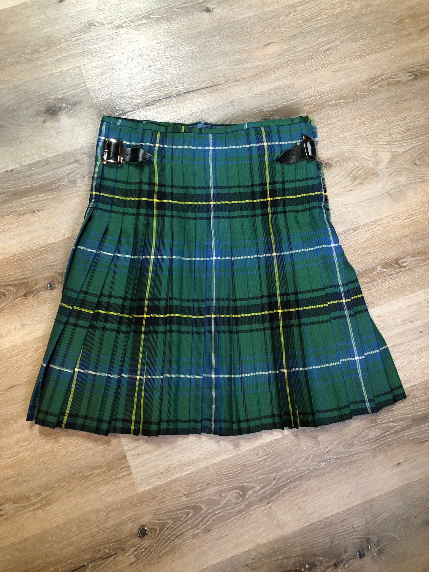 Kingspier Vintage - Green, blue, black, yellow and white plaid/ tartan kilt with leather straps on each side to adjust size. Kilt is partially lined on the inside. Fibres unknown.