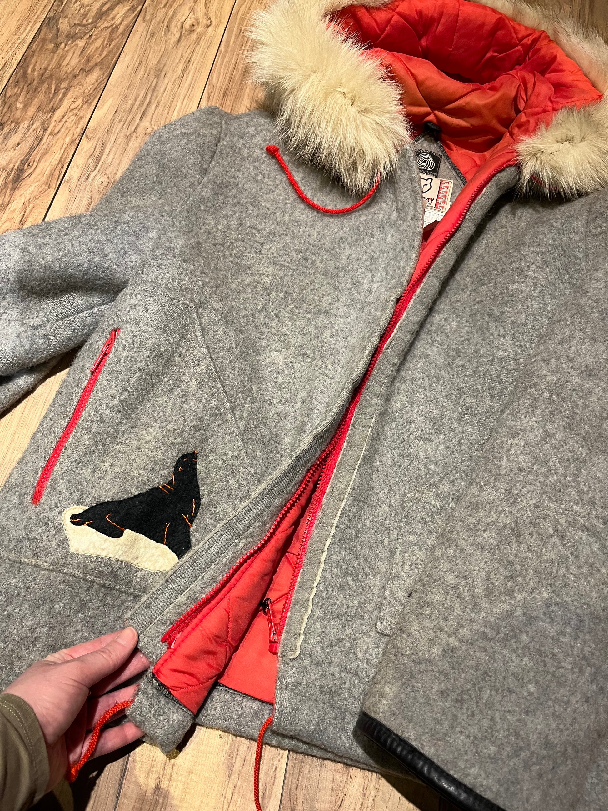 Vintage James Bay100% wool grey northern parka with fox fur trimmed hood, zipper closure, zip front pockets, leather trimmed cuffs, drawstring at waist, quilted lining and felt applique in a seal motif.

Made in Canada
Chest 44”