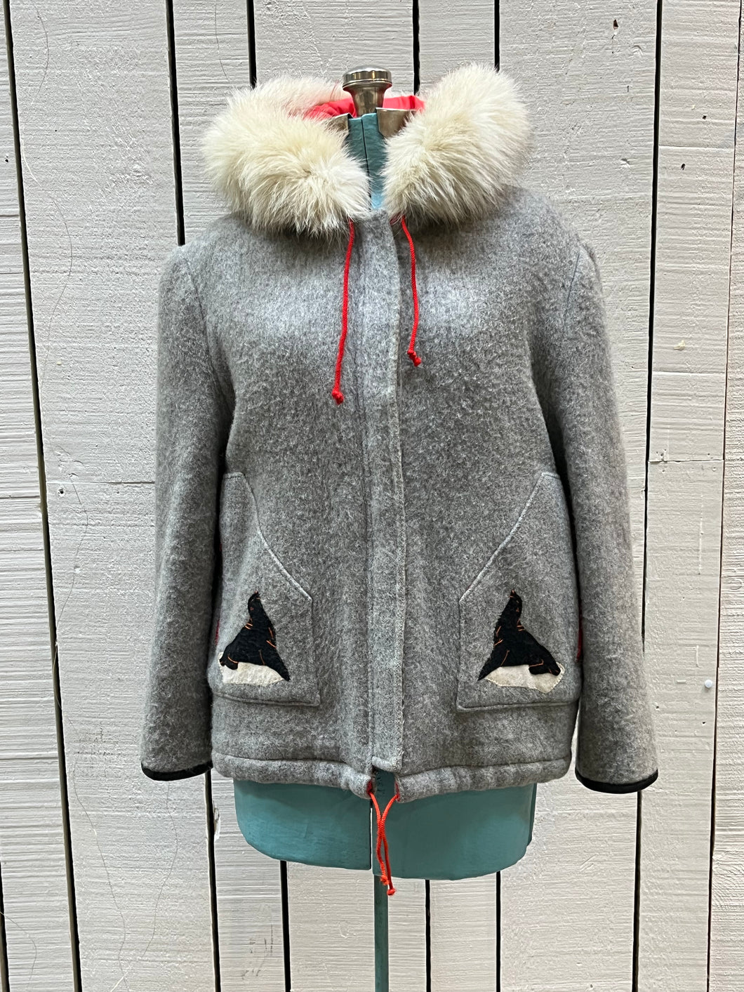 Vintage James Bay100% wool grey northern parka with fox fur trimmed hood, zipper closure, zip front pockets, leather trimmed cuffs, drawstring at waist, quilted lining and felt applique in a seal motif.

Made in Canada
Chest 44”