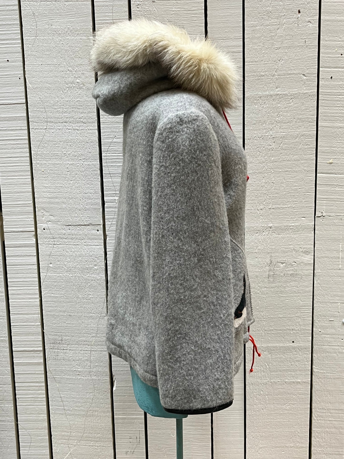 Vintage James Bay100% wool grey northern parka with fox fur trimmed hood, zipper closure, zip front pockets, leather trimmed cuffs, drawstring at waist, quilted lining and felt applique in a seal motif.

Made in Canada
Chest 44”