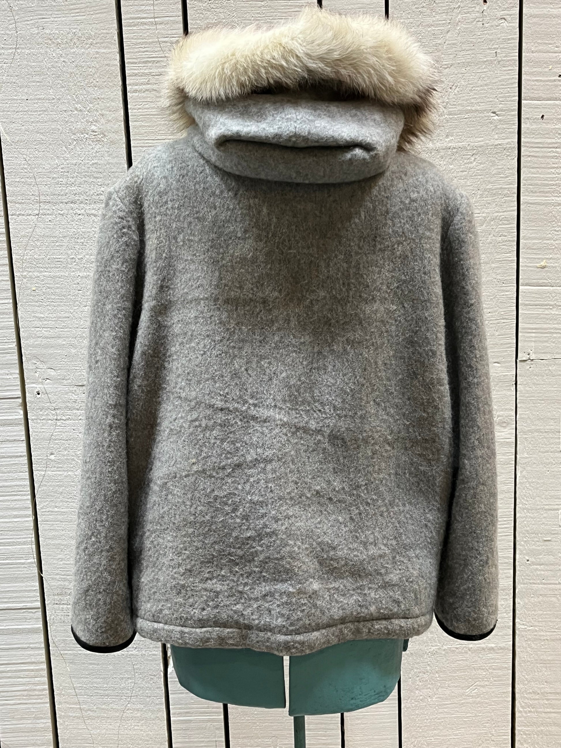 Vintage James Bay100% wool grey northern parka with fox fur trimmed hood, zipper closure, zip front pockets, leather trimmed cuffs, drawstring at waist, quilted lining and felt applique in a seal motif.

Made in Canada
Chest 44”