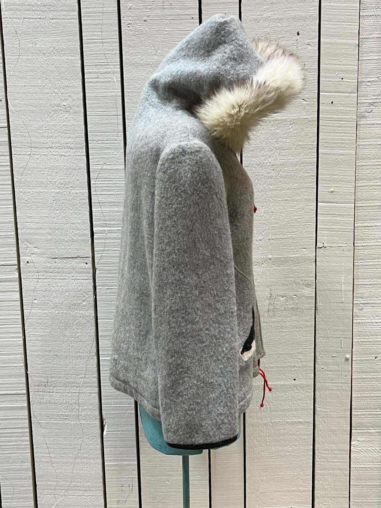 Vintage James Bay100% wool grey northern parka with fox fur trimmed hood, zipper closure, zip front pockets, leather trimmed cuffs, drawstring at waist, quilted lining and felt applique in a seal motif.

Made in Canada
Chest 44”