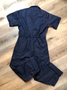 Kingspier Vintage - Vintage Deadstock Anchor Textiles short sleeve navy coveralls with snap closures, elastic waistband, flap pockets on the chest, slash pockets in the front and patch pockets in the back. Union made in Canada. Size medium/ large.