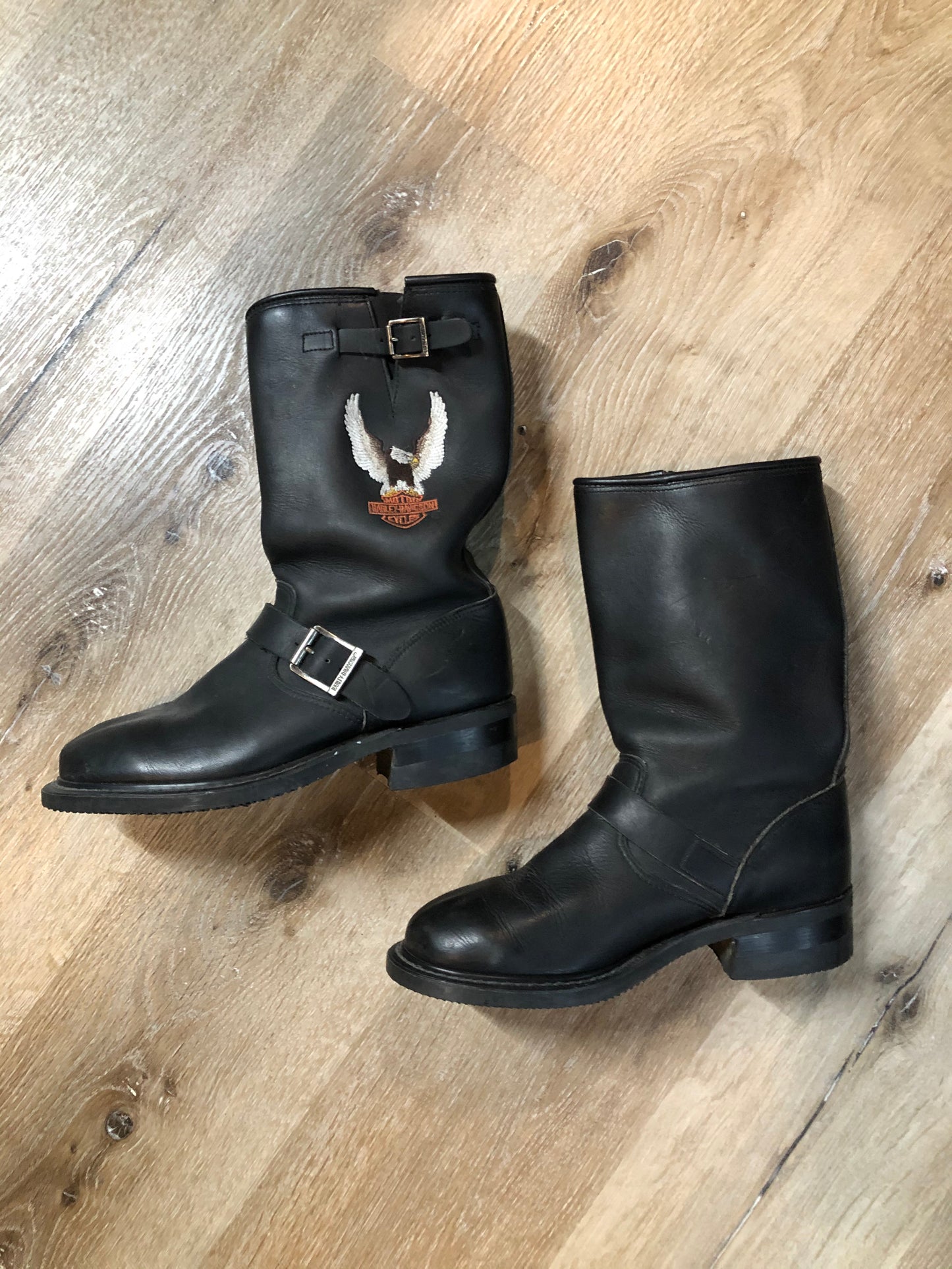 Kingspier Vintage - Harley Davidson black motorcycle boots with harness detail and large Harley Davidson and bald eagle emblem on each outer side of the boot. Boots are in good condition with some over all wear.