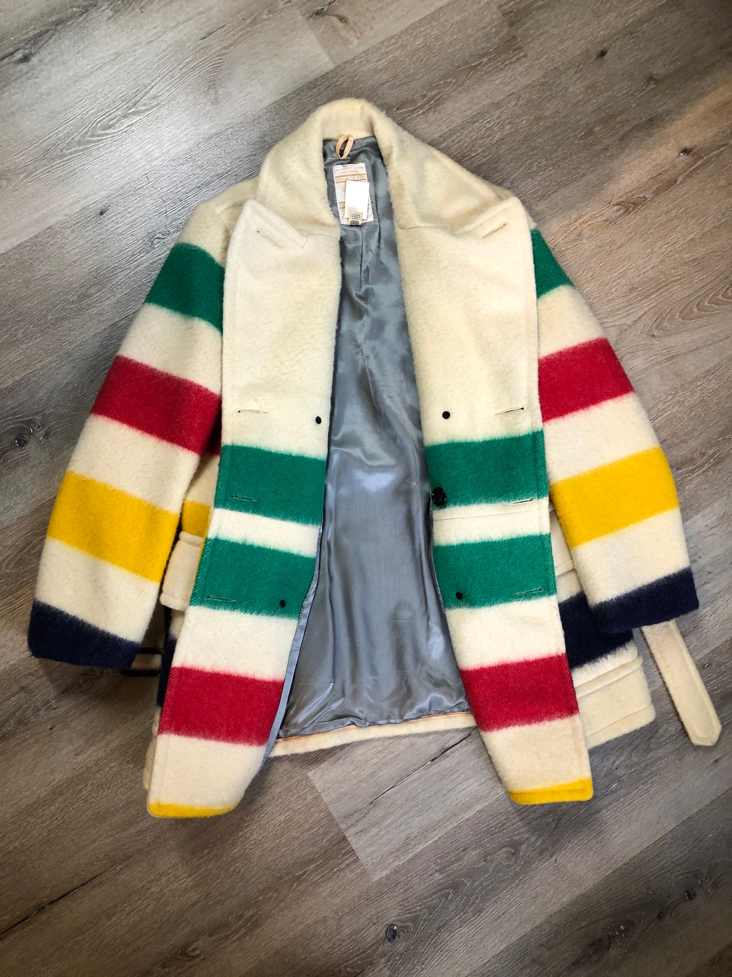 Kingspier Vintage - Genuine Hudson’s Bay Company point blanket coat in the iconic multistripe colours. The coat features flap pockets and hand warmer pockets, double breasted button closures and belt. Made in Canada. Men’s size 46.
