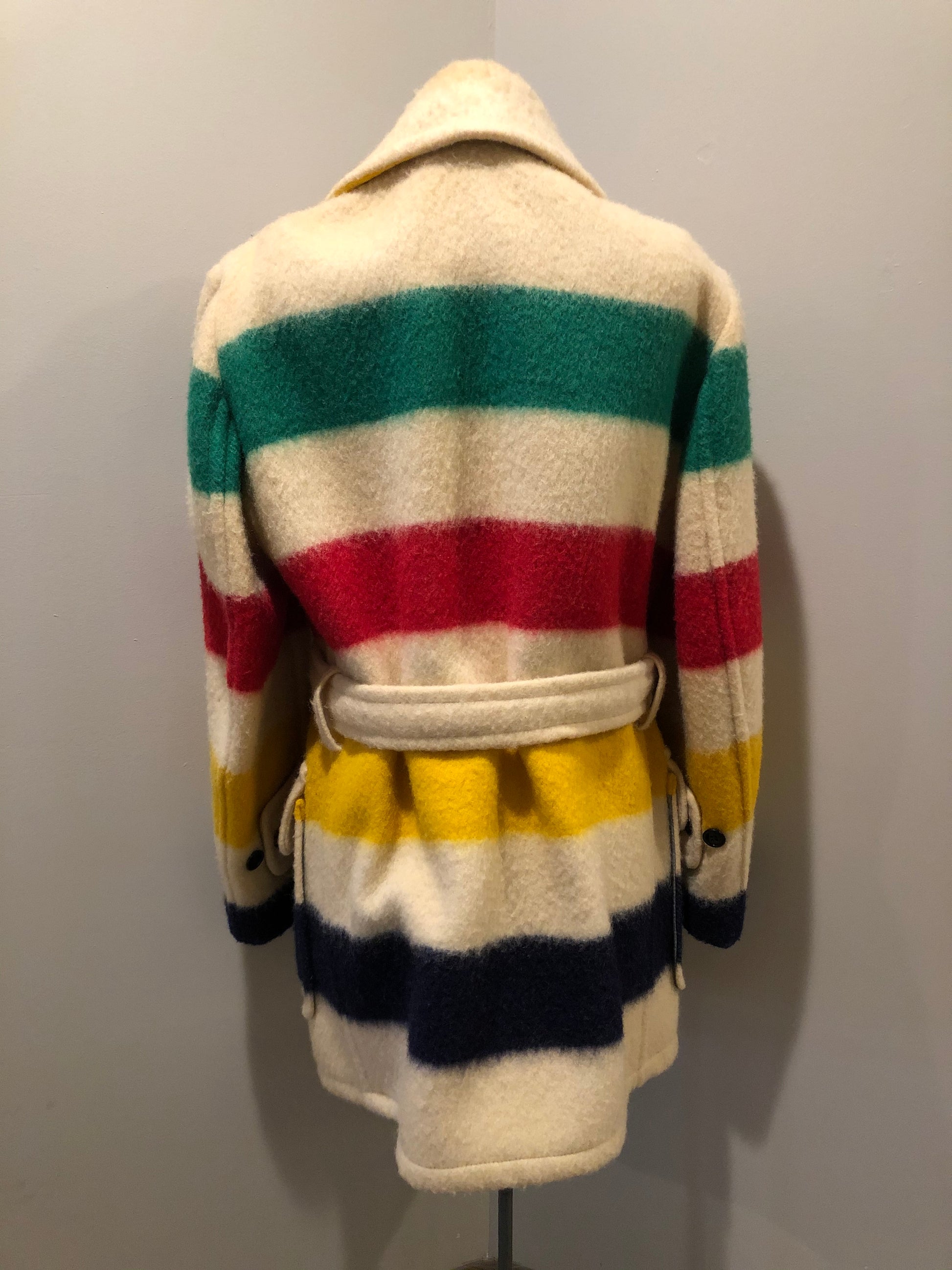 Kingspier Vintage - Genuine Hudson’s Bay Company point blanket coat in the iconic multistripe colours. The coat features flap pockets and hand warmer pockets, double breasted button closures and belt. Made in Canada. Men’s size 46.
