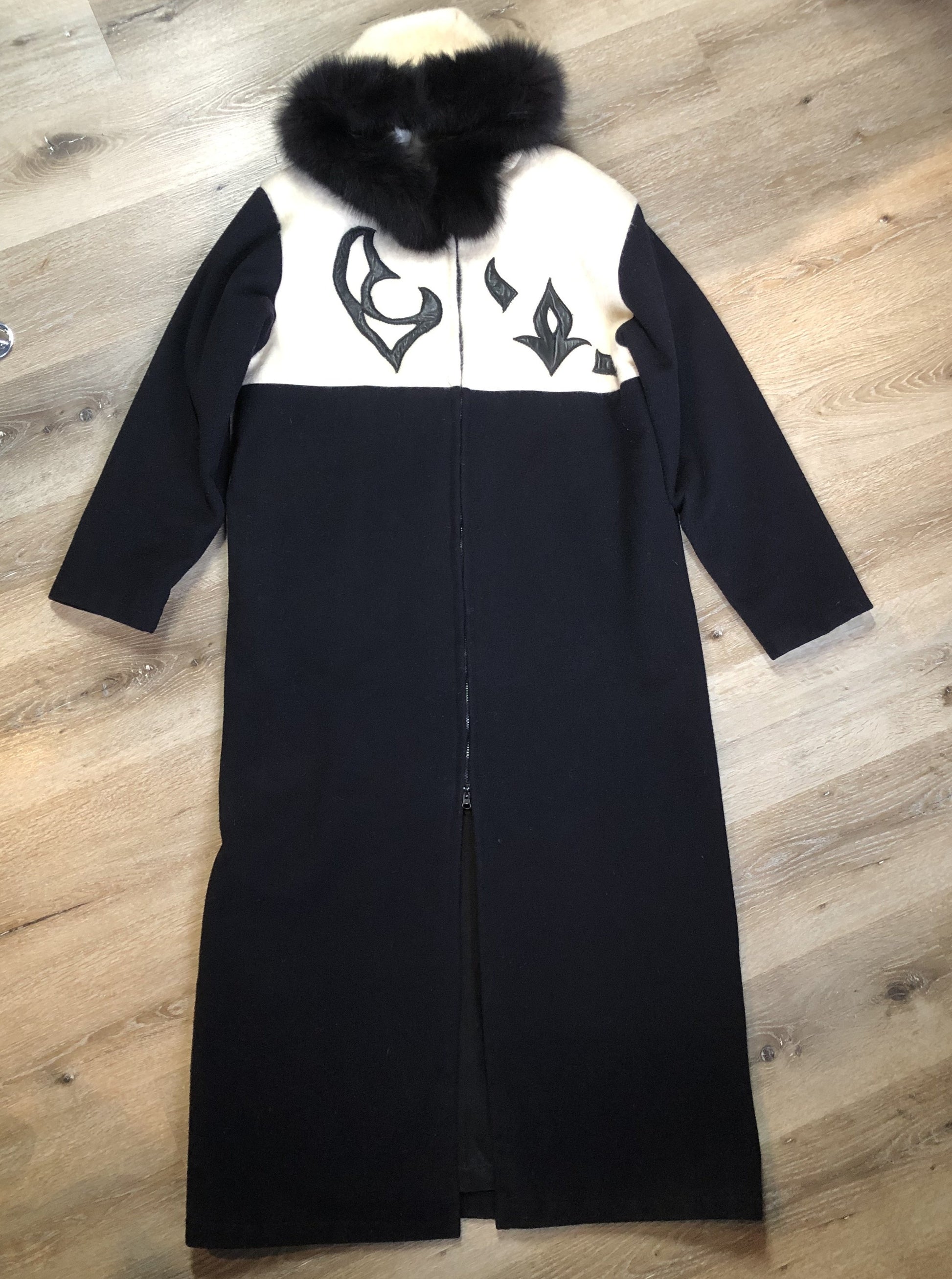 Kingspier Vintage - Linda Lundstrom full length black and white wool coat with fur hood, soft leather applique on the chest and back, zipper closures and a black satin like lining. Made in Canada.
