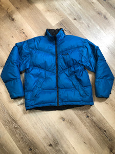 Kingspier Vintage - Vintage Mobius reversible blue and black down filled ski jacket.

This jacket features reversible blue side and black side, zipper closure, two pockets, Logo printed across the back collar,100% polyester shell and 80% down/ 20% feather fill.

Made in Vietnam.
Size Medium.